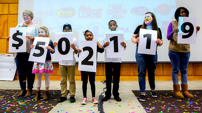 Showing the amount raised during the 18th Mississippi Miracles Radiothon are, from left, Tara Cumberland and her daughter, Sybil, De’Nahri Middleton, De’Niylah Middleton, De’Nahjae Middleton, Hannah Dunaway and Decimbra Middleton.
